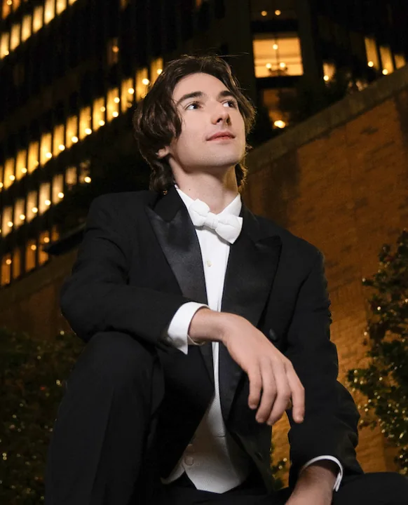 Cade in a tuxedo on a city street at night