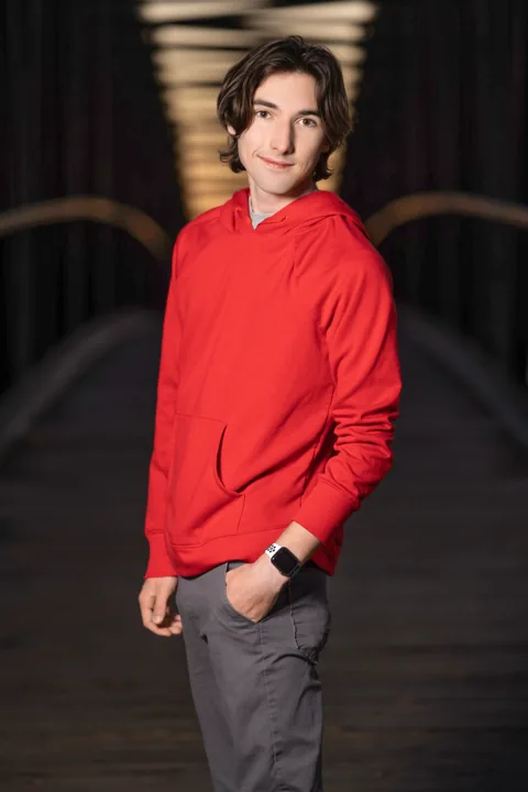 Cade in a red hoodie at night